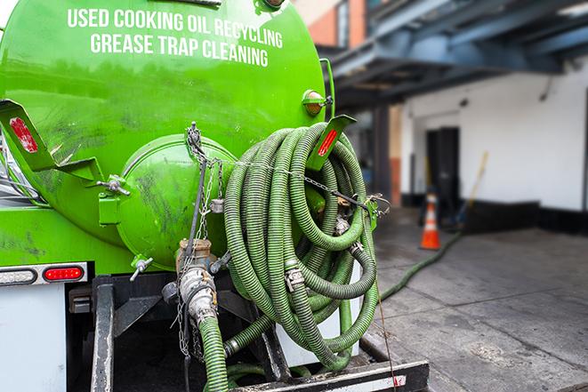 a technician pumping a grease trap in a commercial building in Ashburn, VA